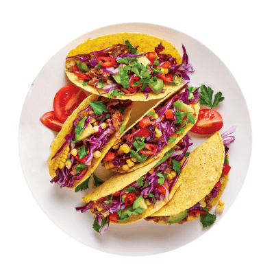 Colorful tacos with vegetables on a white plate
