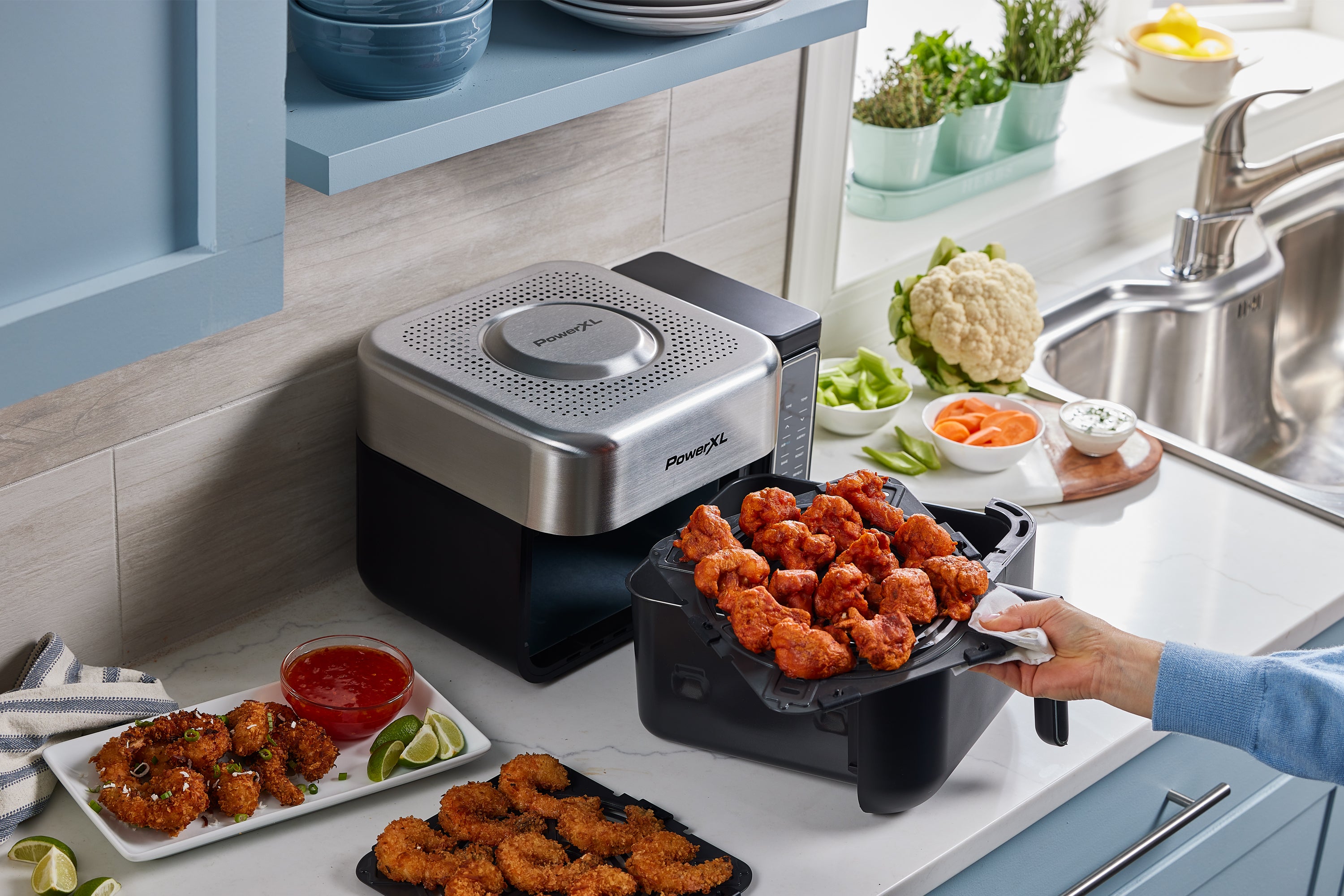 Power Air Fryer on a kitchen counter with cooked food and ingredients.
