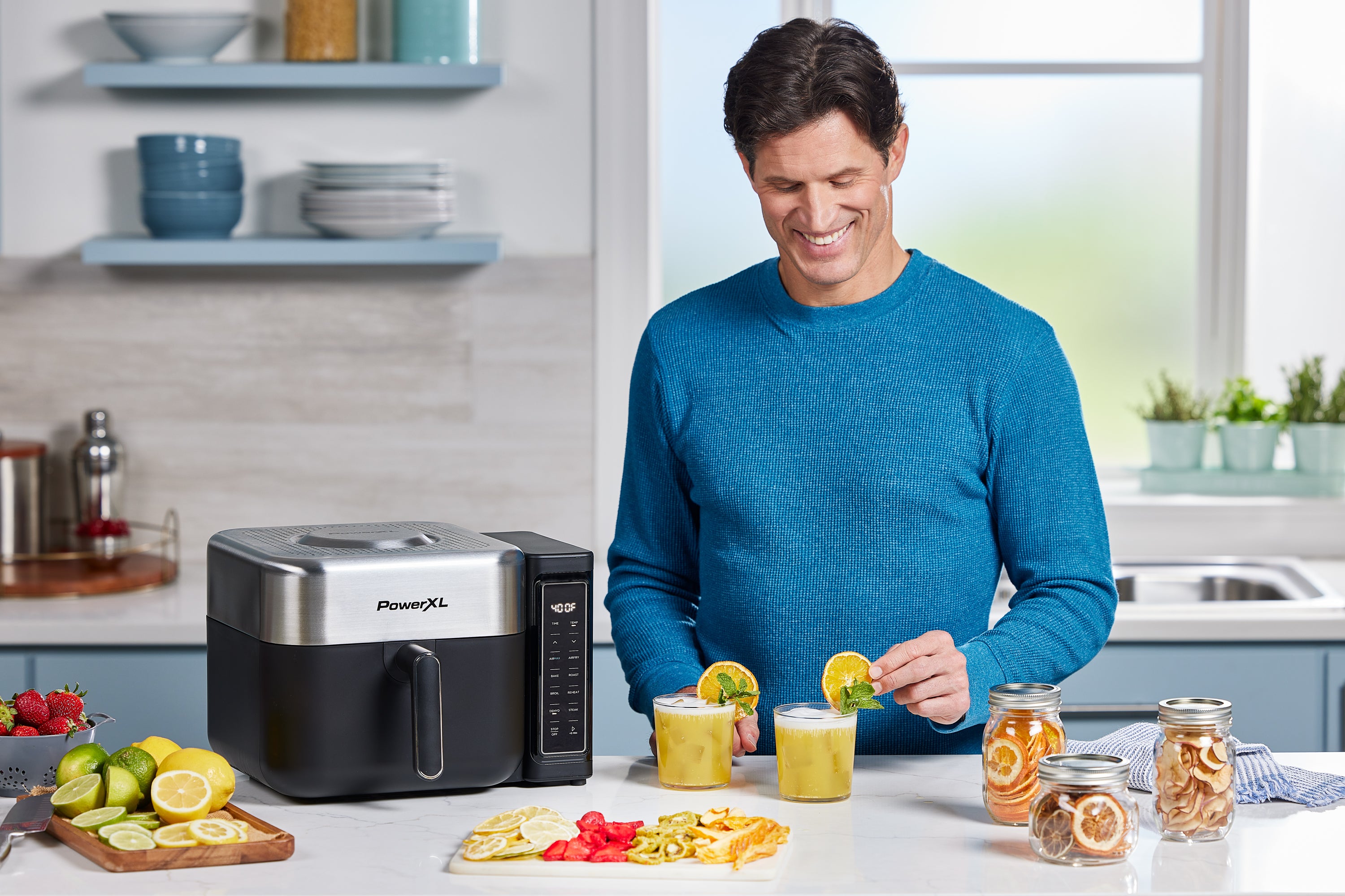Man in a kitchen preparing food with a PowerXL air fryer.