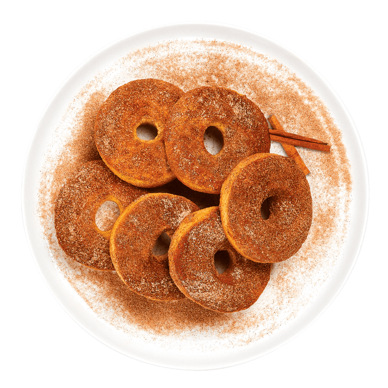 Cinnamon-sugar donuts on a white plate with a green background
