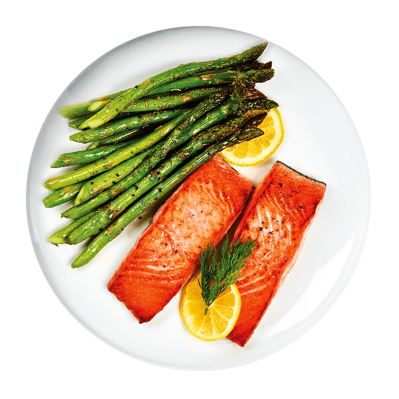 Salmon fillets with asparagus and lemon slices on a white plate