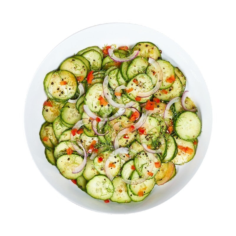 Cucumber salad with onions and red peppers on a white plate